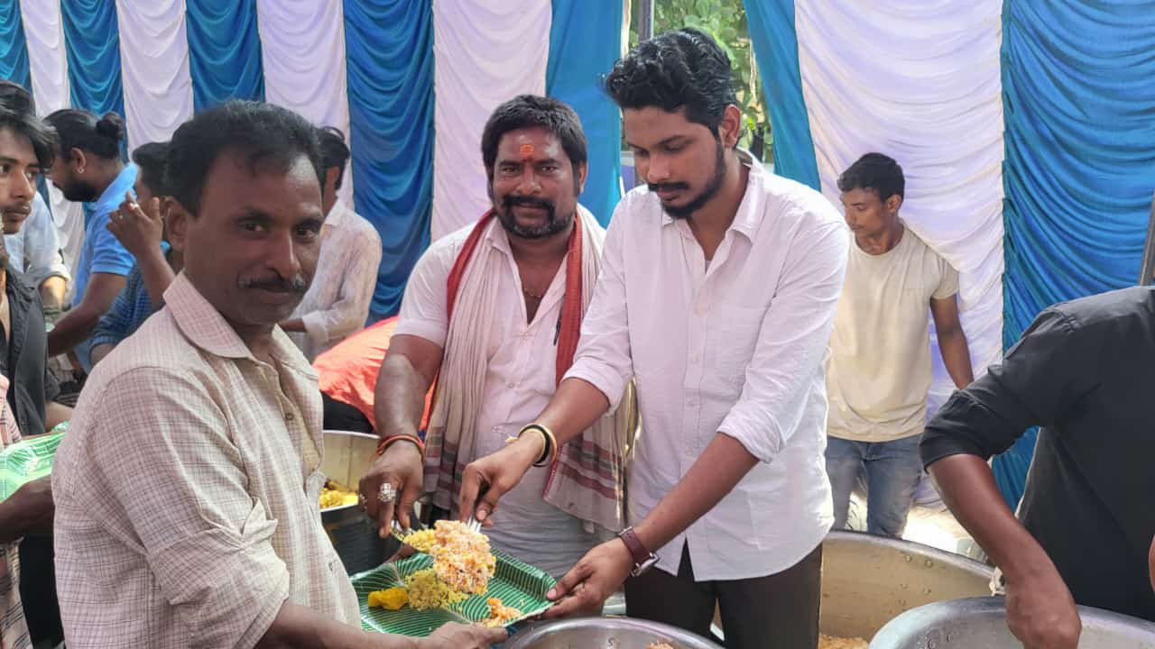 Naveen Kumar serving food to residents at a community meal event
